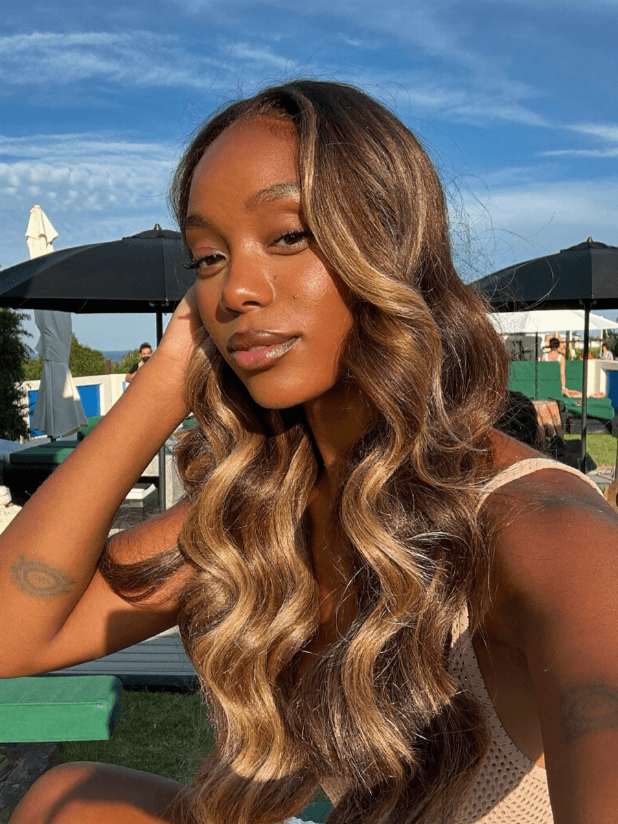 Black woman wearing Coco Brown Balayage wig in golden hour light
